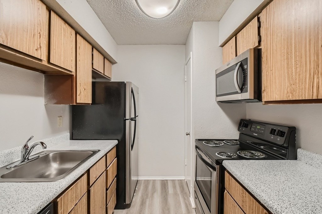 A kitchen with black appliances and wooden cabinets.