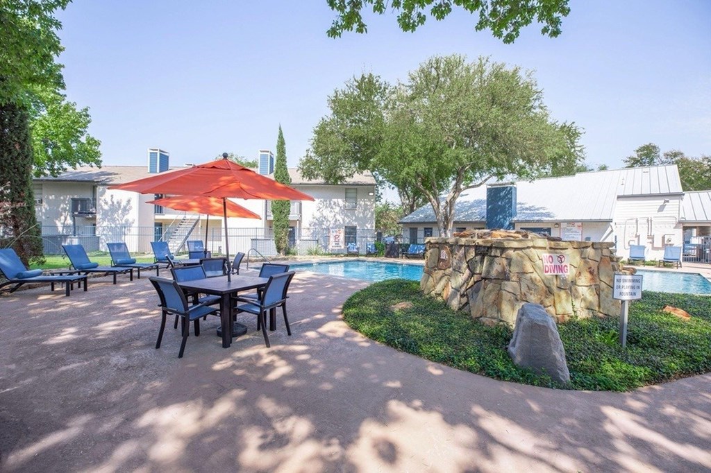A red umbrella is on a table outside.