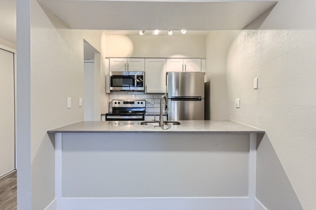 A modern kitchen with stainless steel appliances and a large island.