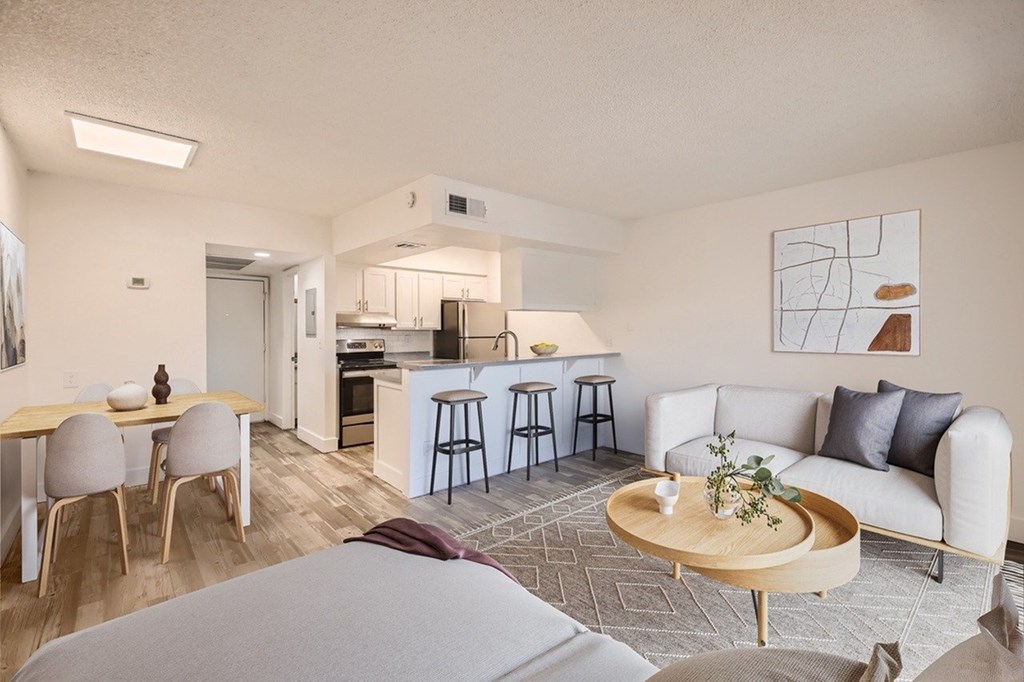 A modern living room with a dining area and kitchen in the background.