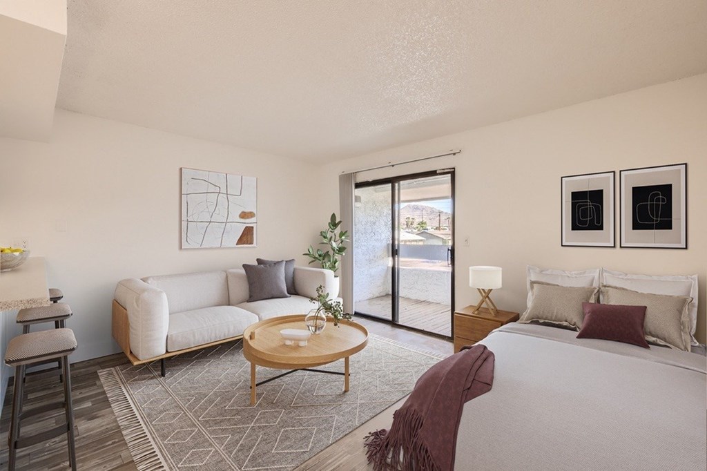 A living room with a couch, a coffee table, and a bed.