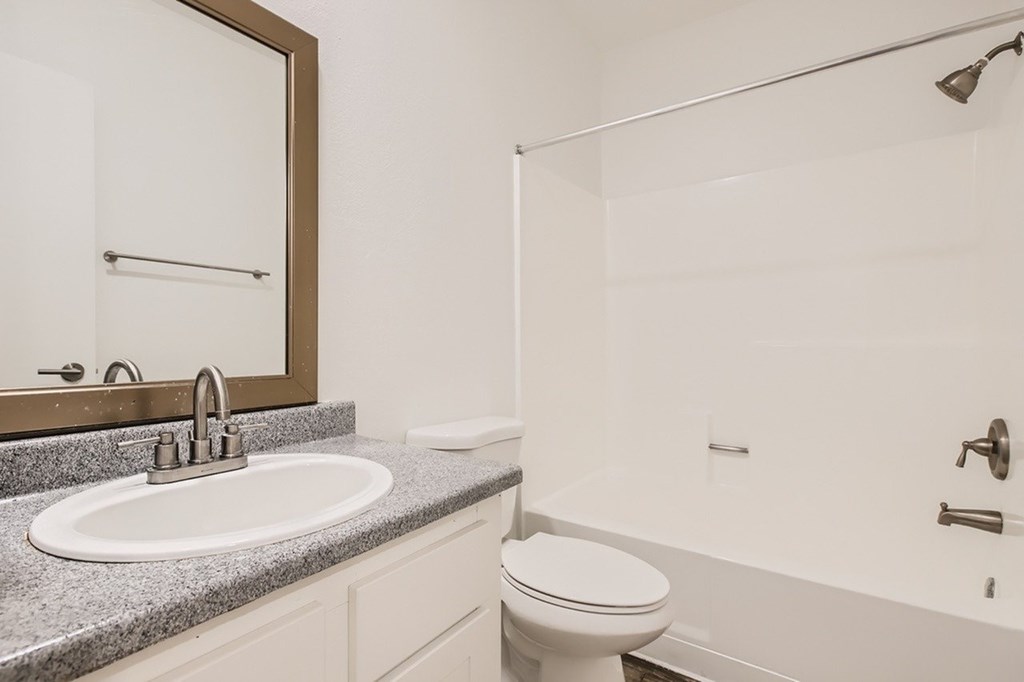 A bathroom with a white toilet, sink, and bathtub.