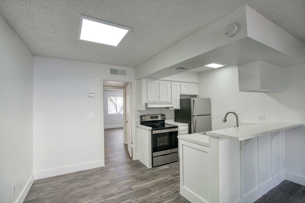 A kitchen with white cabinets and a white countertop.