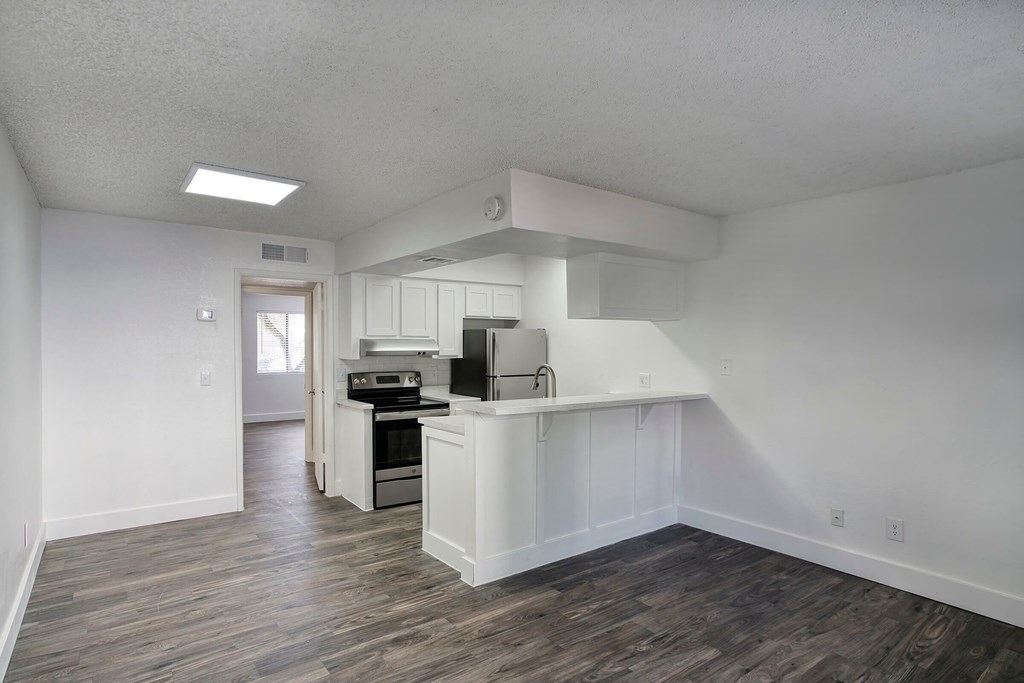 A kitchen with a white counter and a stove top oven.