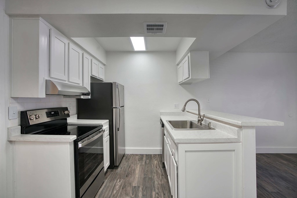A kitchen with white cabinets and a black stove top oven.