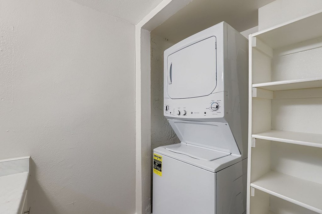 A kitchen with white cabinets and a black refrigerator.