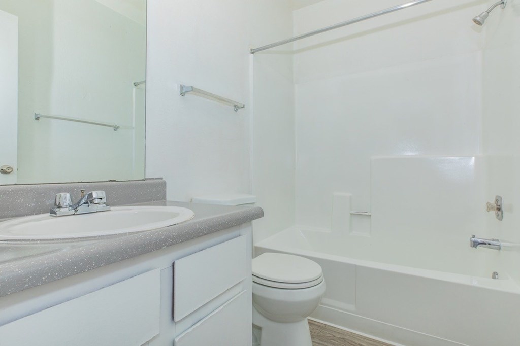 A white bathroom with a toilet, sink, and bathtub.