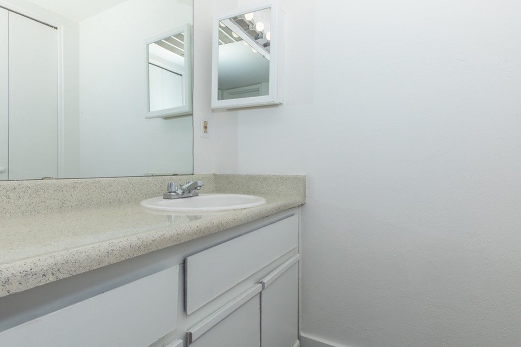 A bathroom with a sink and a mirror.