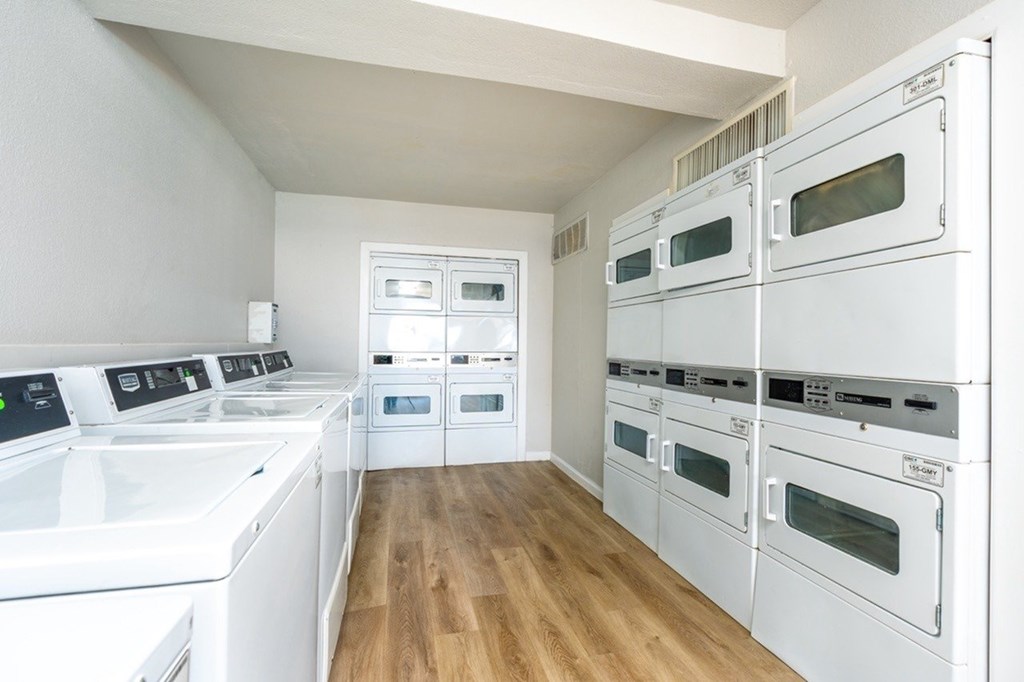 A row of white ovens are lined up in a kitchen.