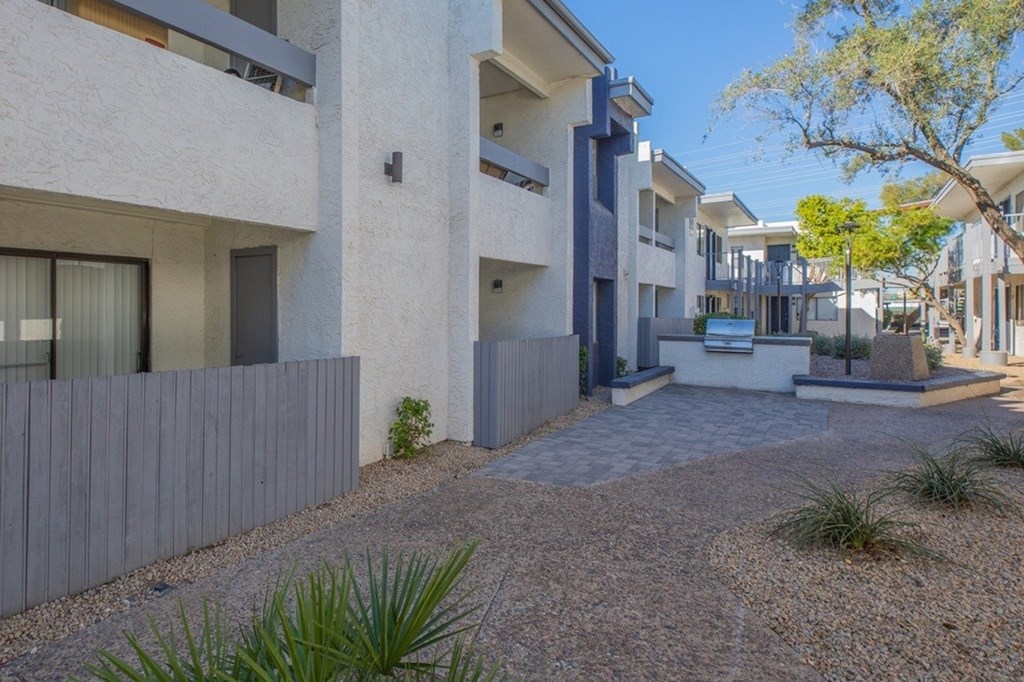 A modern house with a white exterior and a gravel driveway.