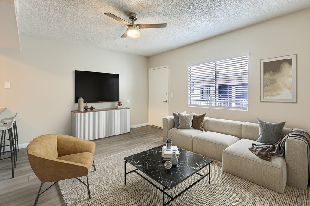 A living room with a white sofa, a yellow chair, and a black coffee table.