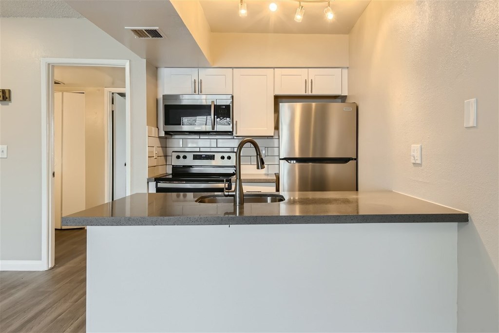 A modern kitchen with stainless steel appliances and a large island.