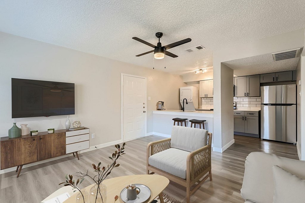 A living room with a ceiling fan and a chair.