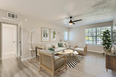 A living room with a sofa set, a coffee table, and a ceiling fan.
