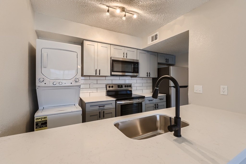 A kitchen with a white fridge, stove, and oven.