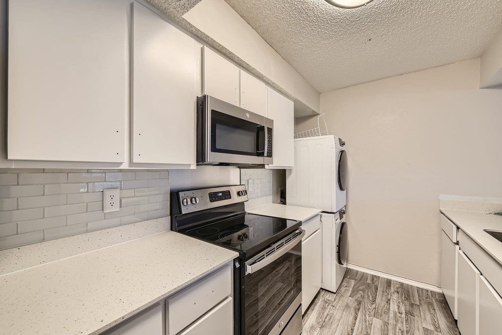 A kitchen with white cabinets and a black stove top oven.