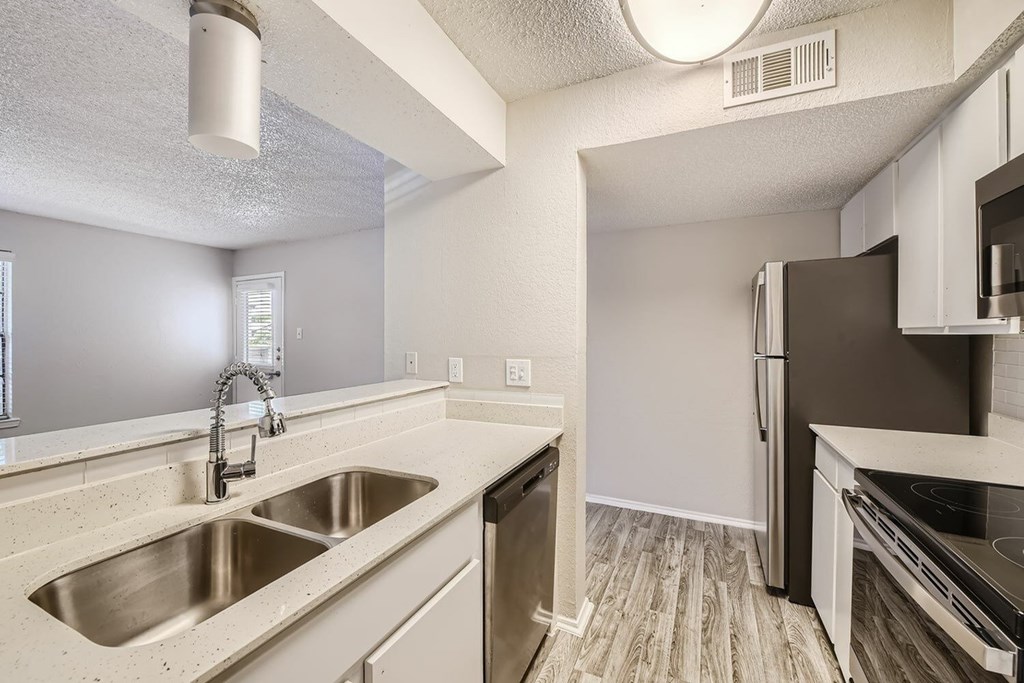 A kitchen with a sink and a refrigerator.