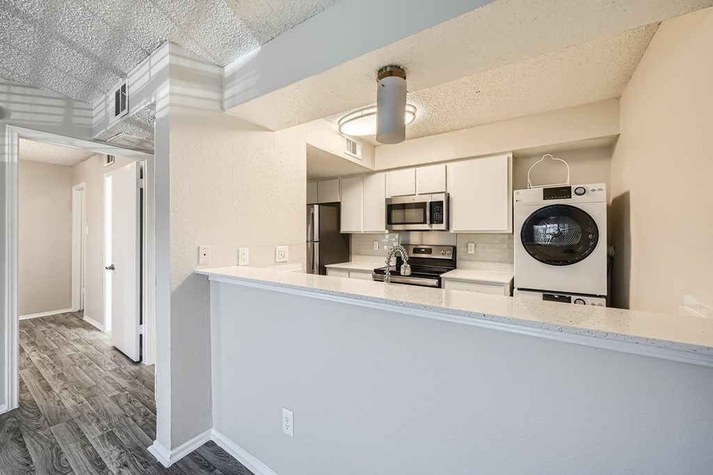 A kitchen with white cabinets and a microwave above the stove.