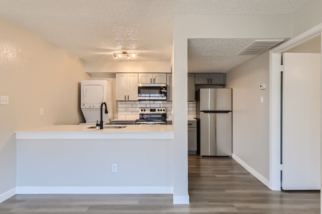 A kitchen with white cabinets and a white island.