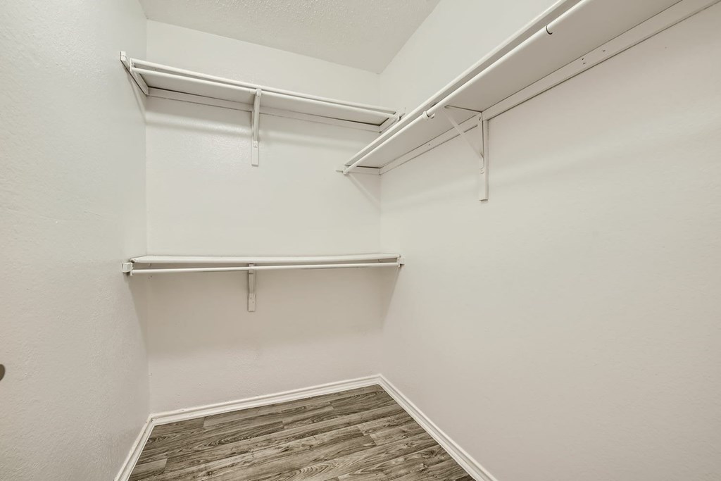 A white wall with a white shelf and a white ceiling.