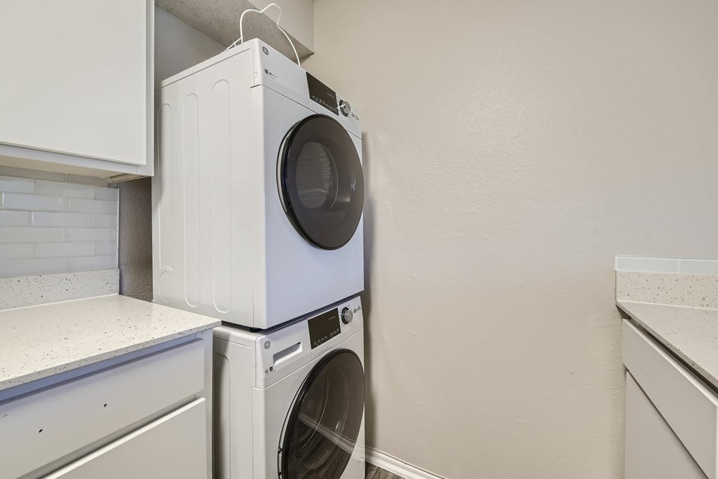 A white washing machine and dryer in a laundry room.