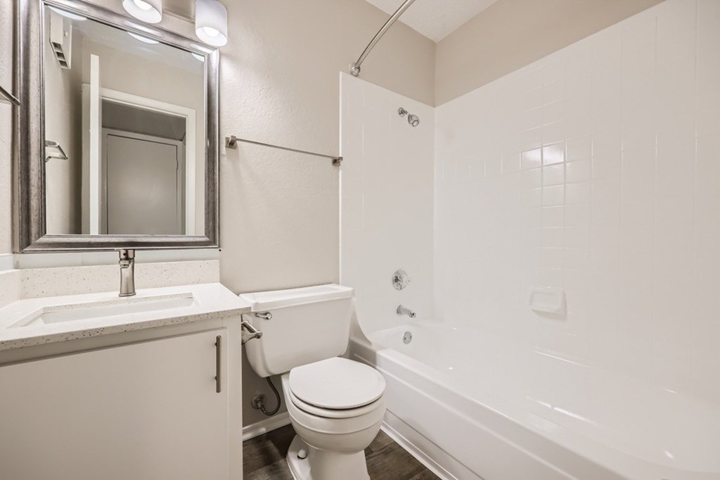 A white bathroom with a toilet, sink, and bathtub.