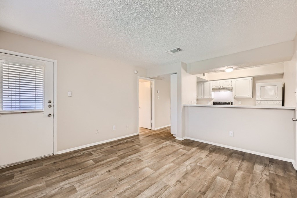 A room with wooden flooring and white walls.