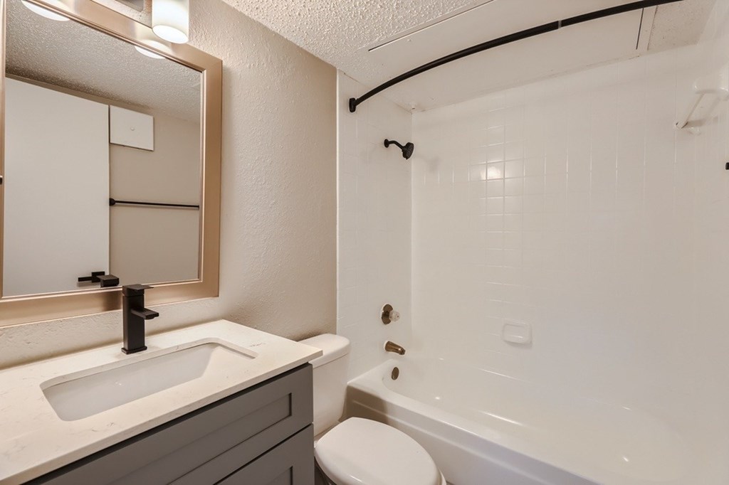 A bathroom with a white sink and a white toilet.
