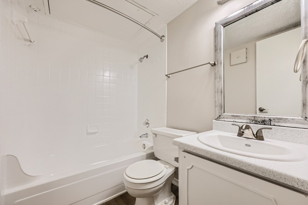 A white bathroom with a toilet, sink, and bathtub.