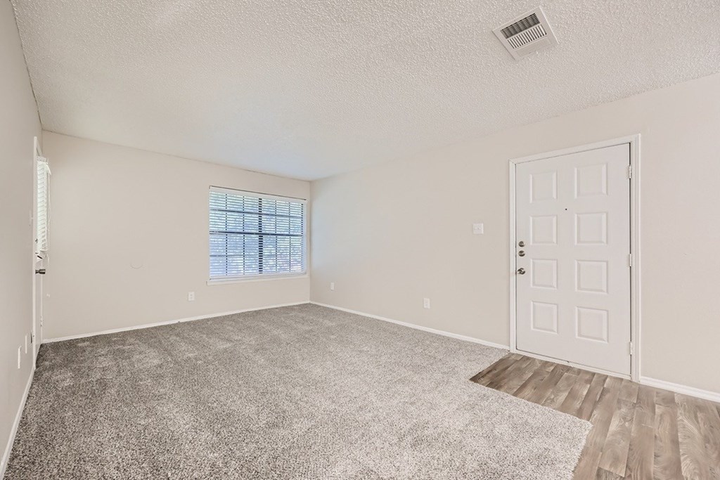 A room with a white door and a window with blinds.