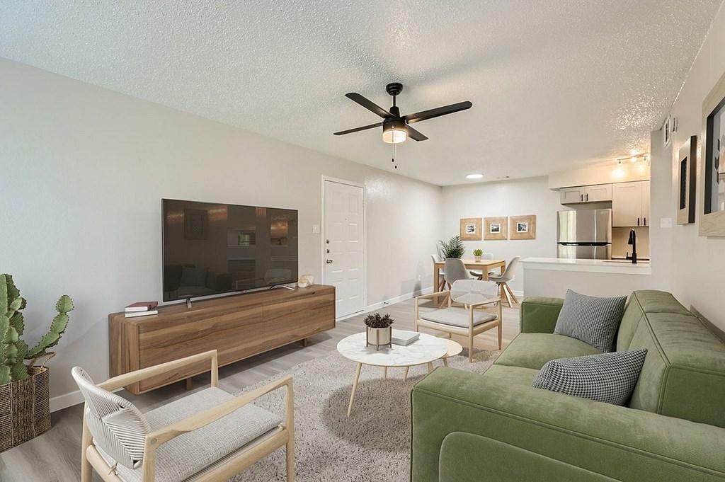A living room with a green couch and a wooden entertainment center.
