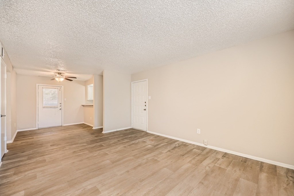 A room with wooden flooring and a ceiling fan.
