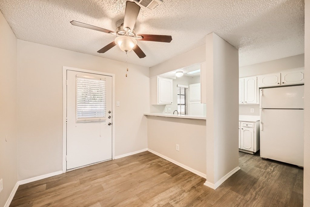 A white room with a ceiling fan and a washer and dryer.