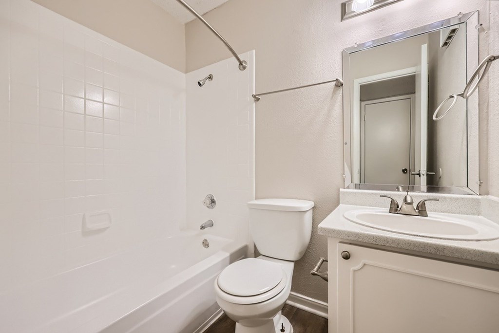 A white bathroom with a toilet, sink, and bathtub.