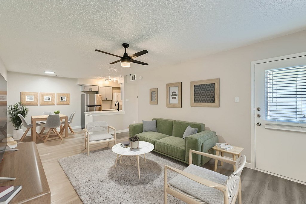 A living room with a green couch and a white coffee table.