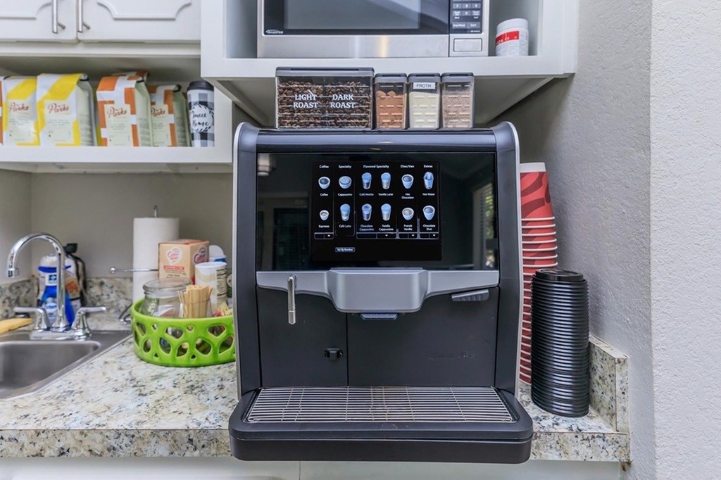 A black coffee machine is on a kitchen counter.