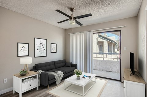 A living room with a grey couch, a white coffee table, and a ceiling fan.