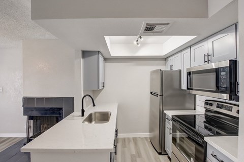 A modern kitchen with stainless steel appliances and a white countertop.