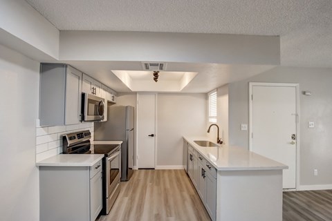 A kitchen with white appliances and cabinets.