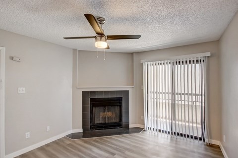 A living room with a fireplace and a ceiling fan.