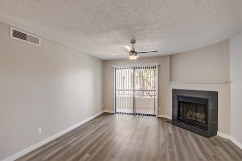 A room with a fireplace and a ceiling fan.