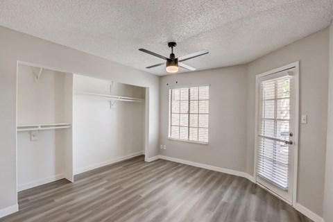 A room with a ceiling fan and a door.