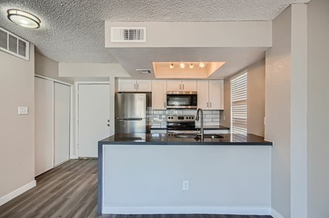 A kitchen with a stainless steel refrigerator, oven, and microwave.