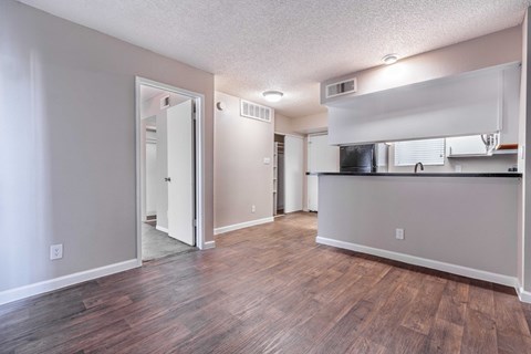 A room with a wooden floor and a white wall.