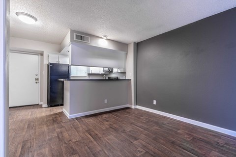 A kitchen area with a refrigerator, cabinets, and a countertop.