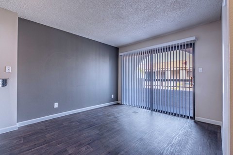A room with a sliding door and wooden flooring.