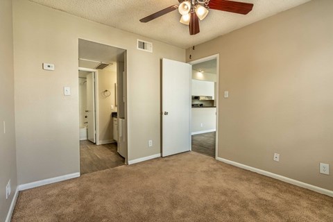 A room with a ceiling fan and carpeted floor.