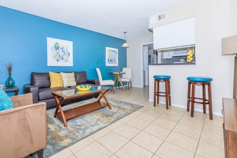 A living room with a blue wall and a brown leather couch.