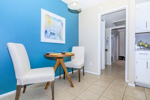 A blue wall with a white chair and a small table with a book on it.