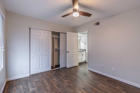 A room with a ceiling fan and sliding doors.